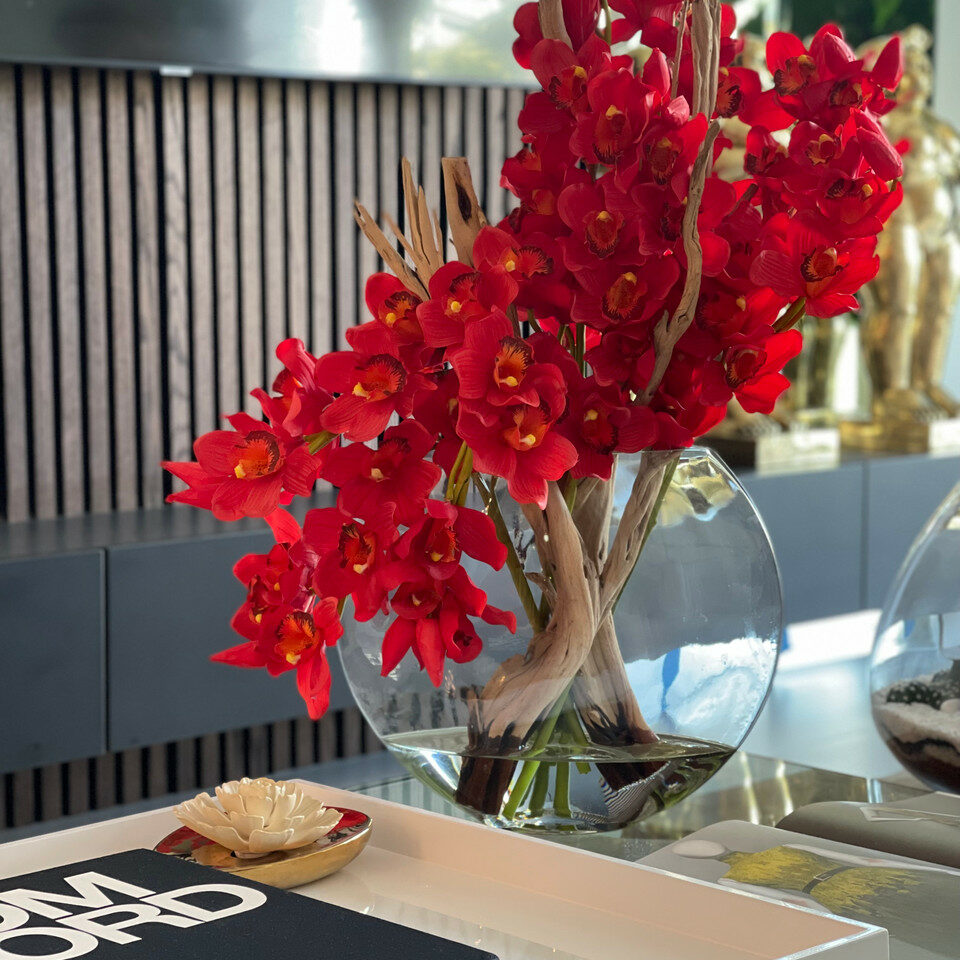 Rote Cymbidium-Orchideen im Mond-Pflanzgefäß