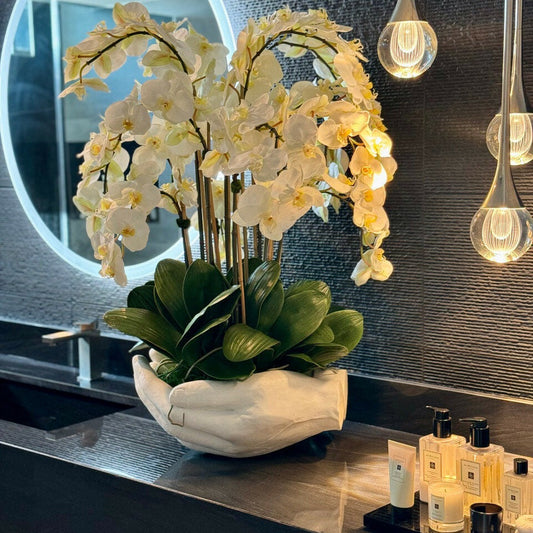 Weißer Phalaenopsis-Orchideenstrauß in Vase mit Skulptur "Offene Hände"